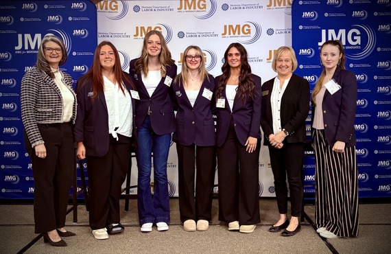 Montana Department of Labor Commissioner Sarah Swanson posing for a picture with smiling IGNITE conference attendees.