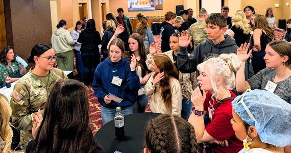 A soldier talking to young people at the IGNITE conference.